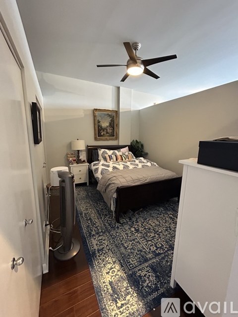 A bedroom with a bed, a ceiling fan, and a rug.