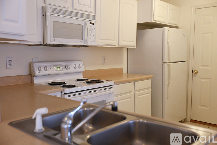 A kitchen with white cabinets and appliances.