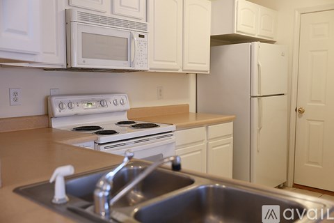 A kitchen with white cabinets and appliances.