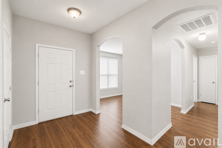 A spacious room with wooden floors and white walls.