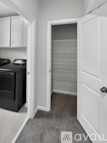 A black oven is in a kitchen with white cabinets.