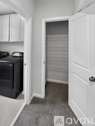 A black oven is in a kitchen with white cabinets.