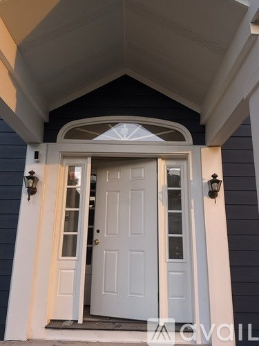 A white door is open to a home.