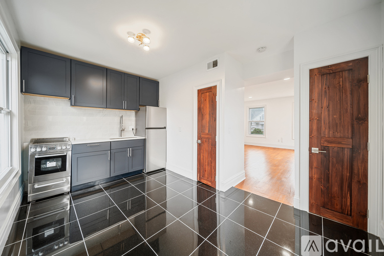 A kitchen with black cabinets and a black tile floor.