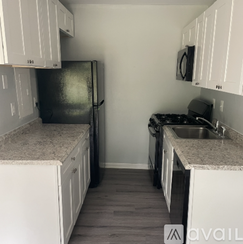 A kitchen with white cabinets and a granite countertop.