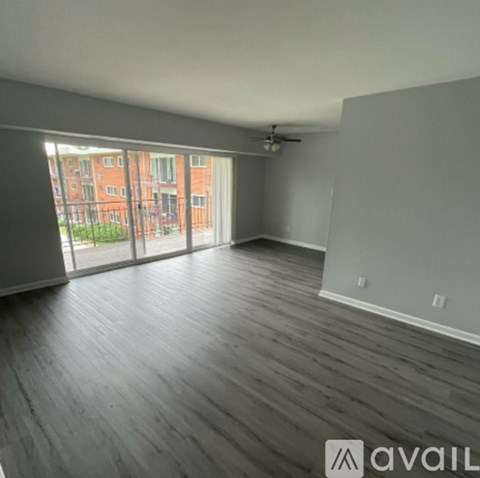 A room with wooden flooring and a ceiling fan.