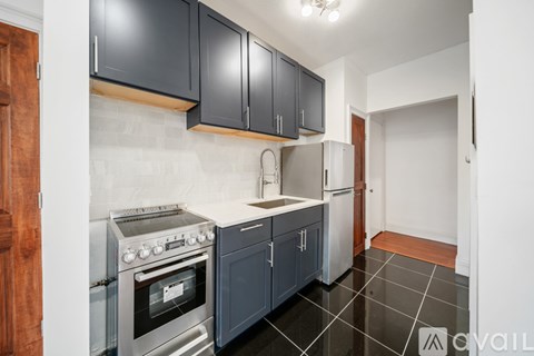 A kitchen with a stove top oven and a refrigerator.