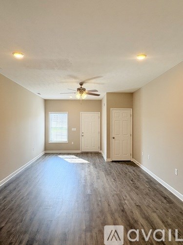 A room with a ceiling fan and two doors.