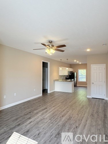 A spacious room with a ceiling fan and lighting fixtures.