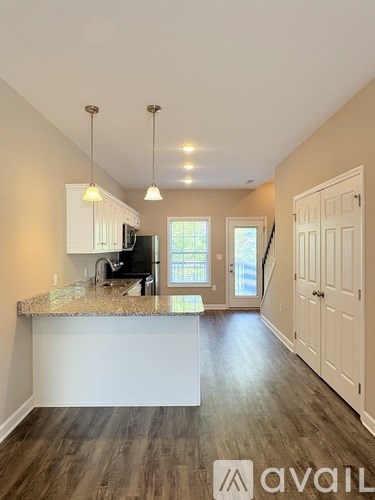 A kitchen with granite countertops and a bar area.