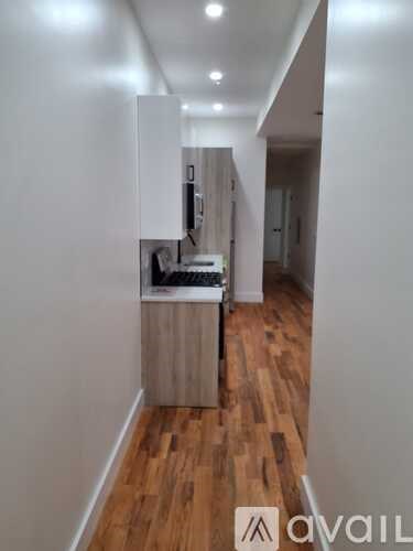 A kitchen area with wooden floors and white walls.
