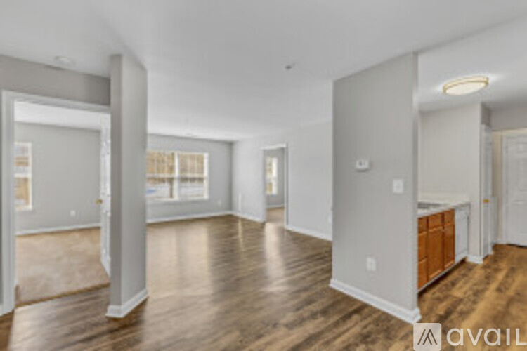 A spacious room with wood flooring and white walls.