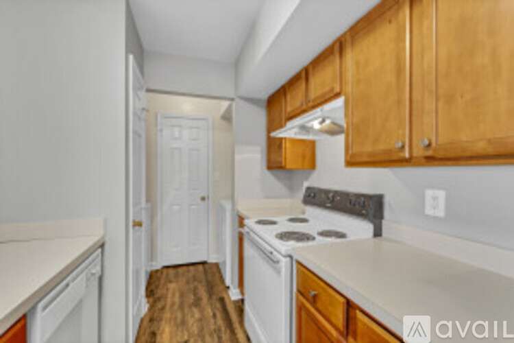 A kitchen with wooden cabinets and a white stove top oven.