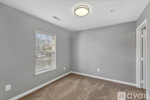 A room with a window and a door is available for rent.