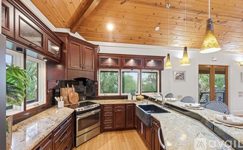A kitchen with wooden cabinets and a stone countertop.