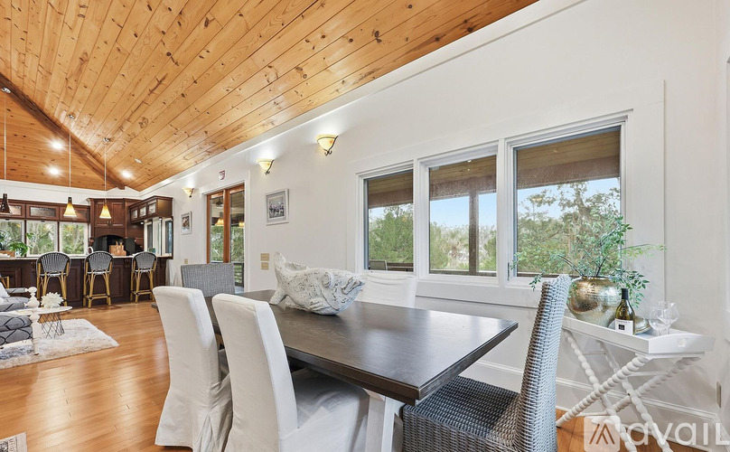 A dining room with a wooden table and chairs.