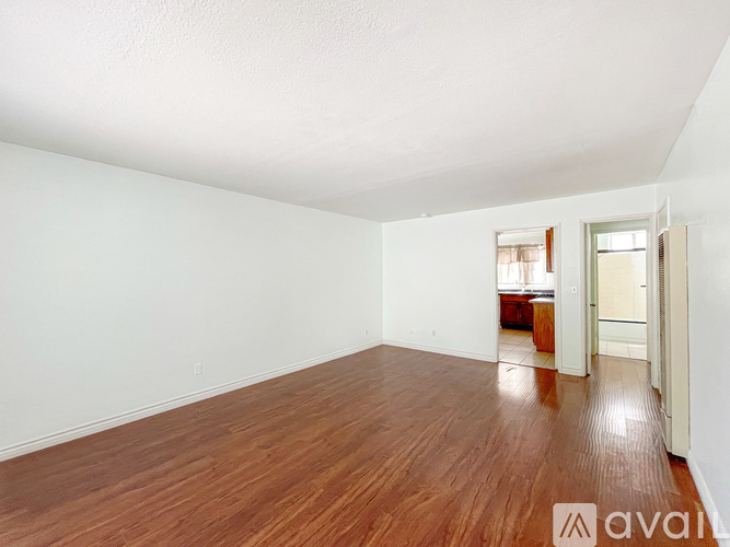 A room with wooden flooring and white walls.