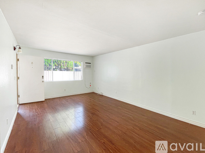 Empty room with wooden floor and white walls.