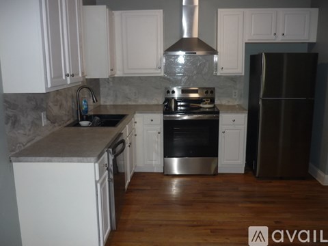A kitchen with a stove top oven and a refrigerator.