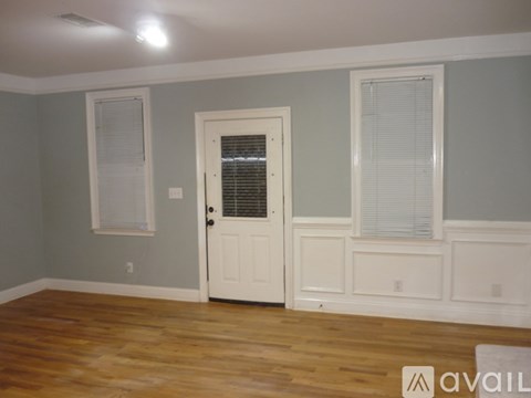 A room with a white door and a window with blinds.