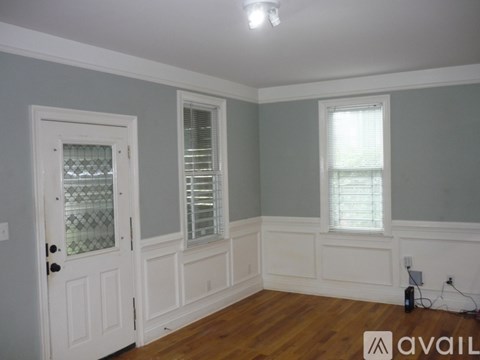 A room with a white door and a window with blinds.
