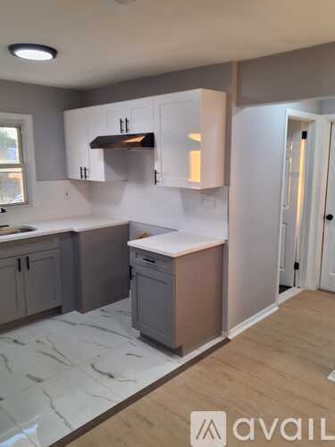 A kitchen with a marble floor and white walls.