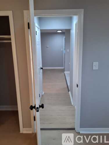 A white door is open to a hallway.