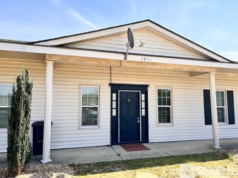A white house with a black door and a small porch.