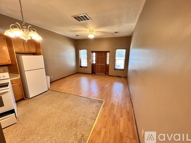 A kitchen with white appliances and wooden cabinets.