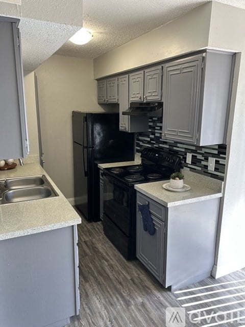 A kitchen with a black refrigerator, stove, and oven.