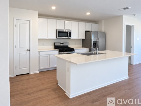 A kitchen with white cabinets and a wooden floor.