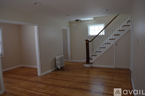 A room with wooden floors and a staircase.