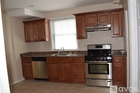 A kitchen with wooden cabinets and a granite countertop.