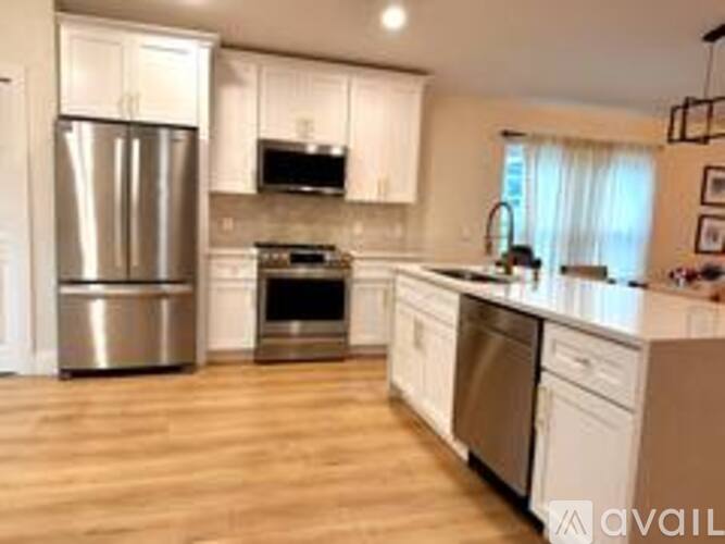 A kitchen with wooden floors and stainless steel appliances.