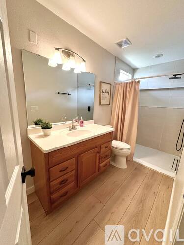 A bathroom with a wooden vanity and a walk-in shower.