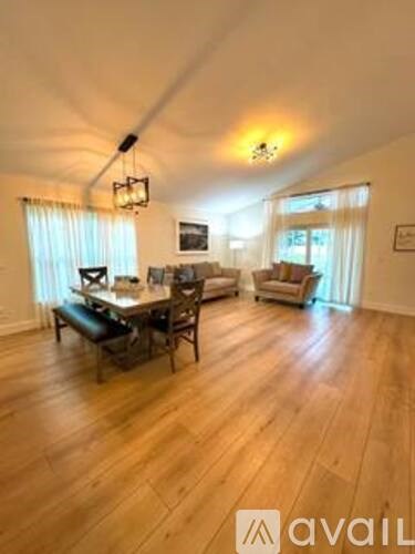 A living room with a dining table and chairs.