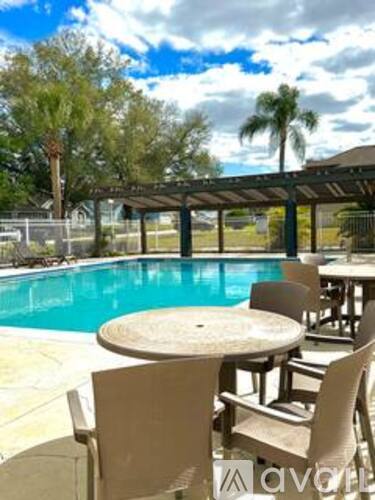 A poolside table and chairs with a clear blue sky in the background.