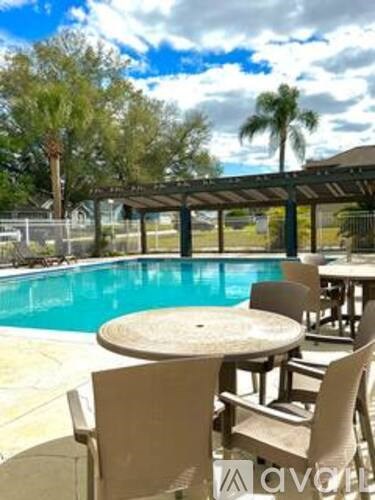 A poolside table and chairs with a clear blue sky in the background.