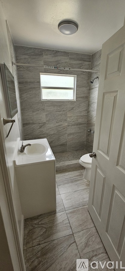 A bathroom with a toilet, sink, and shower.