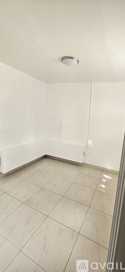 A room with a white ceiling and tiled floor.