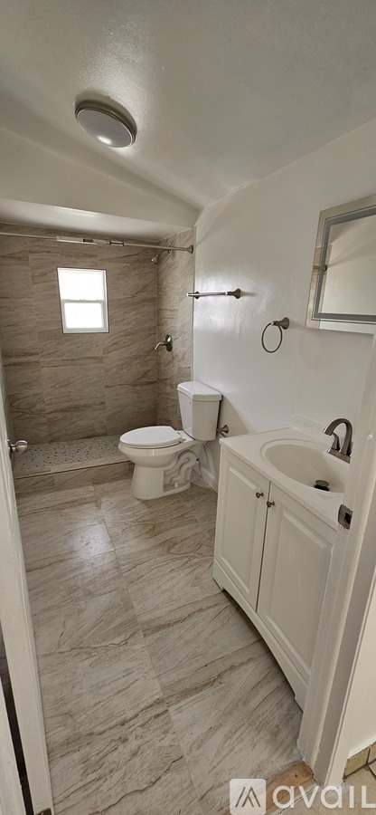 A bathroom with a toilet, sink, and shower.