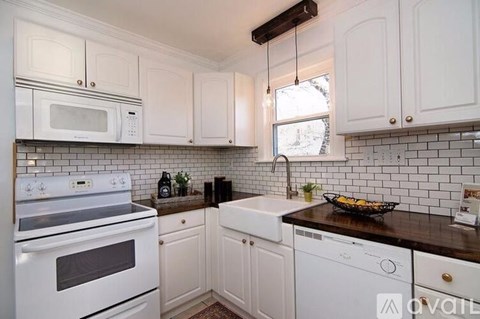 A kitchen with white cabinets and a white oven.