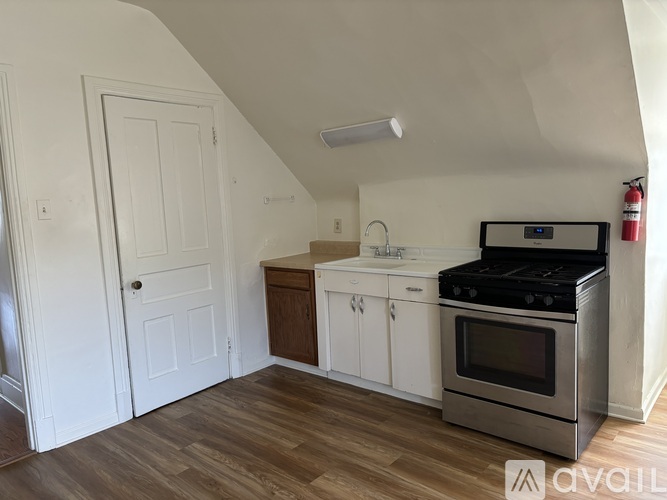 A kitchen with a stove, sink, and cabinets.