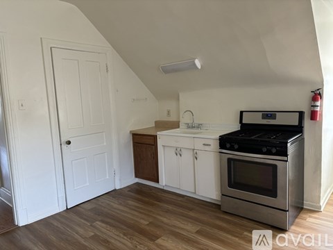 A kitchen with a stove, sink, and cabinets.