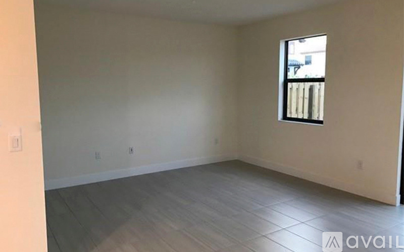 A room with a window and wooden flooring is available for rent.