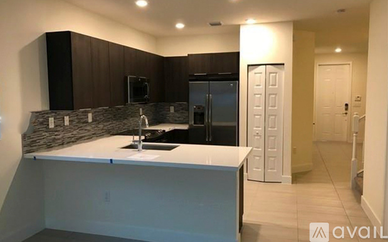 A kitchen with a sink and a refrigerator.