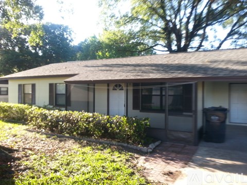 A house with a brown roof and a white exterior is shown.