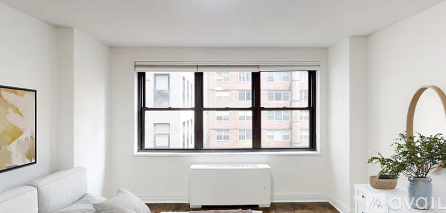 A living room with a large window and a white couch.
