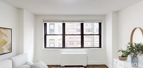 A living room with a large window and a white couch.