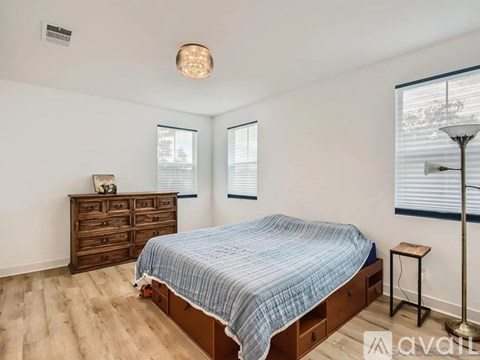 A bedroom with a bed, dresser, and window.
